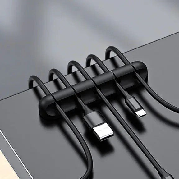 Set organizatoare cabluri din silicon negru aranjate pe suprafață de sticlă, vedere de sus